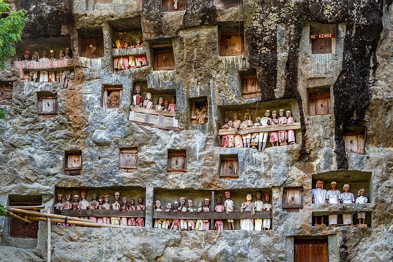 Cliff face full of tau tau (carved figures) and burial chambers at the funerary site of Lemo in Tana Toraja